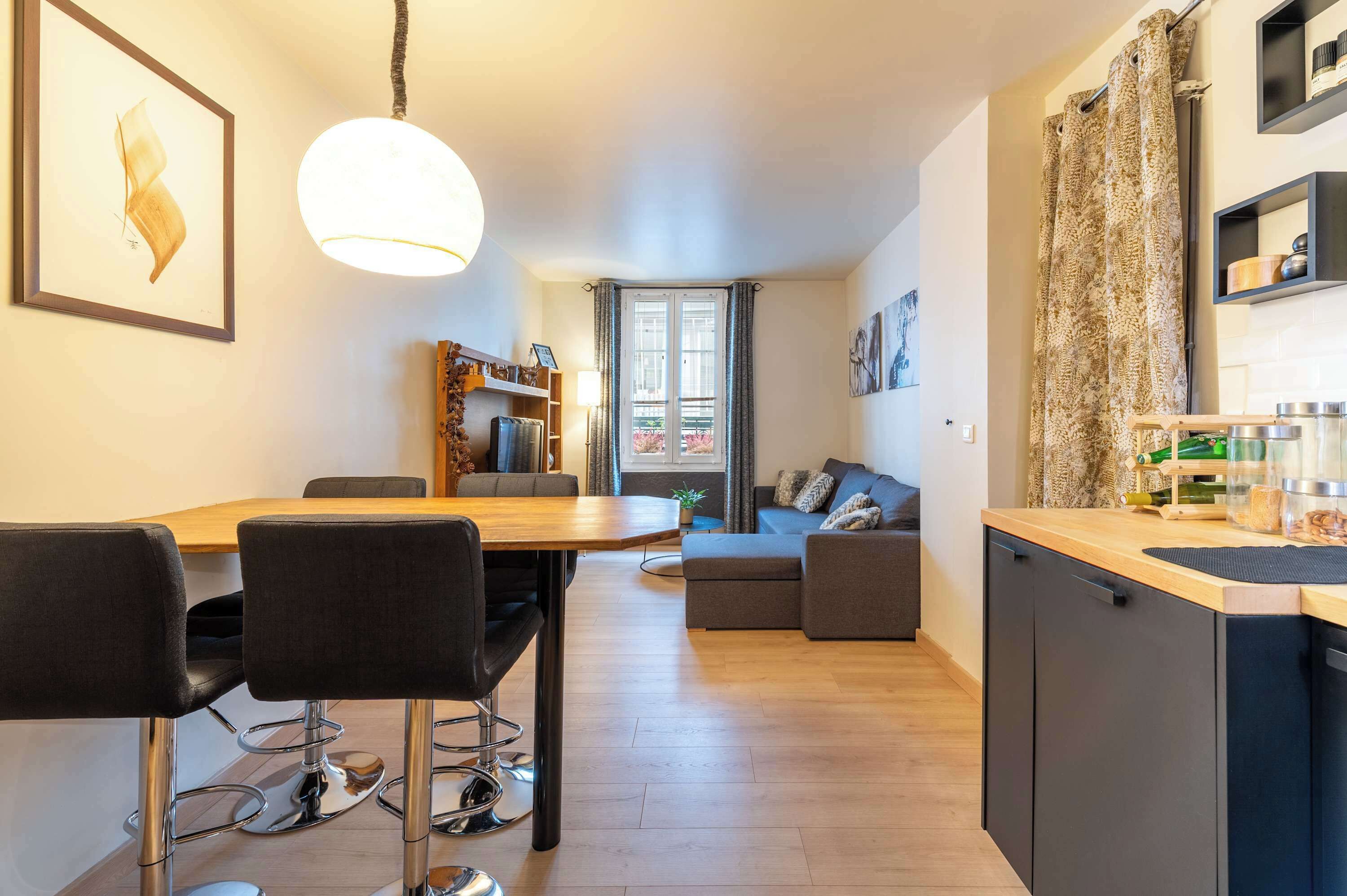Une cuisine moderne avec un coin repas, un canapé et une vue sur l’extérieur.
