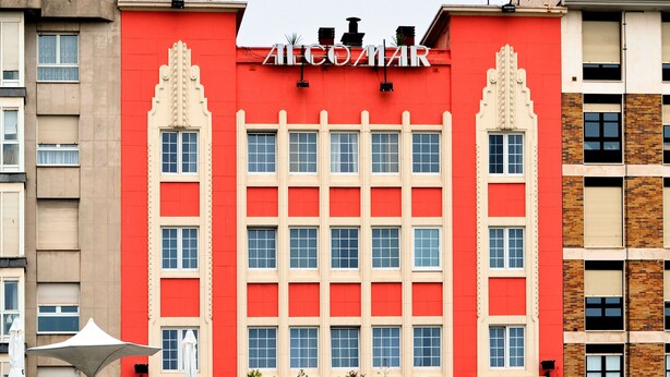 Um edifício com fachada vermelha e o nome 'Alicomar' em destaque.