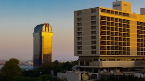 Um hotel moderno com um grande letreiro da Hilton, fachada de vidro e design de varanda estruturada.