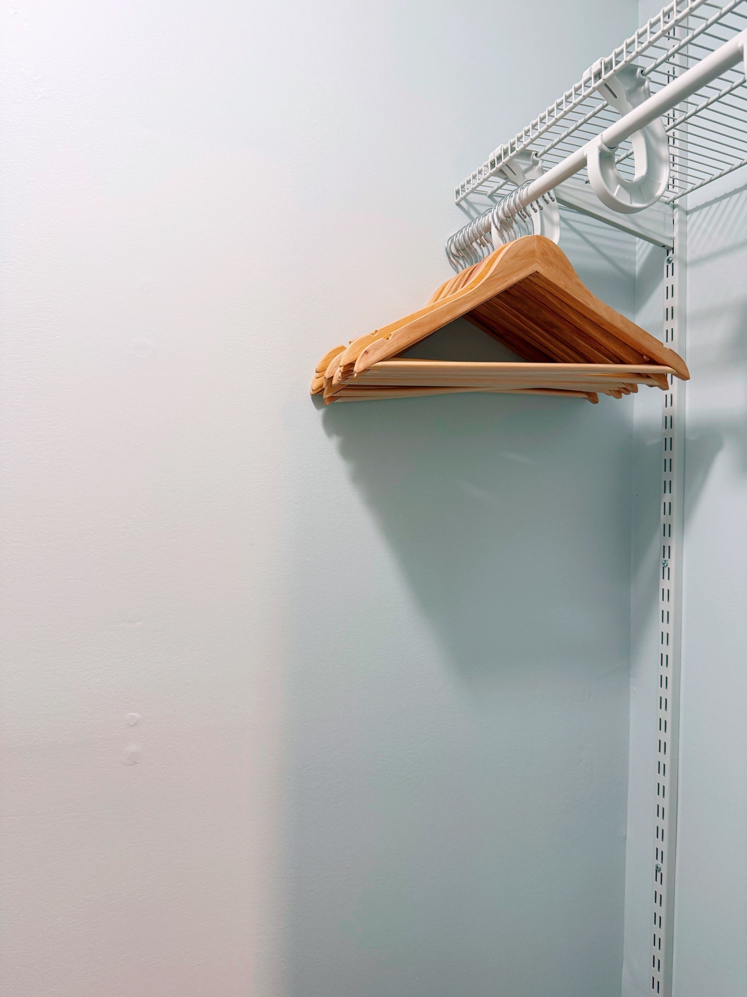A metal shelving unit with a wooden hanger.