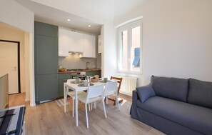 A compact living space with a kitchenette, dining area, and a sofa.