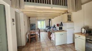 Una cocina compacta con zona de comedor, estufa integrada y ventana que proporciona luz natural.