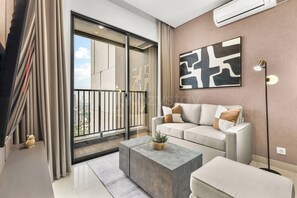 Een moderne woonkamer met een bank, salontafel en een groot raam met gordijnen.