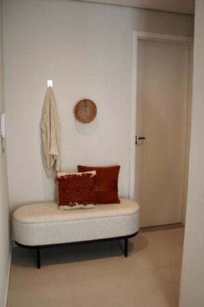 A hallway with a bench, a door, and a wall-mounted towel rack. - Corporate Stays First Living - 407 (Asunción)