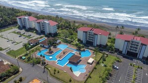 A hotel with multiple buildings, a swimming pool complex, and a beach view. - Acogedora casa de playa, Condominio Malaga Bejuco (Bejuco)