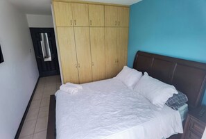Ein Schlafzimmer mit Bett, Kleiderschrank und Tür.