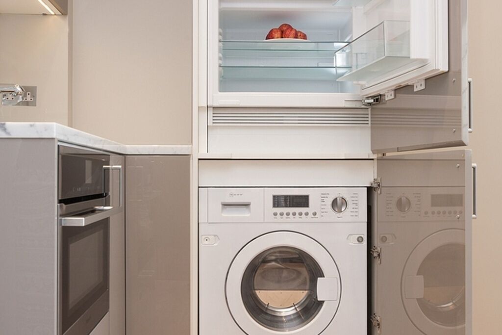 A compact laundry area with a washing machine, dryer, and a microwave.