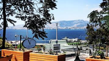 A seaside view with a clock, wooden planters, and a clear sky.