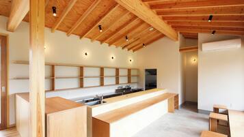 A modern kitchen with wooden beams, a central island, and built-in shelves.