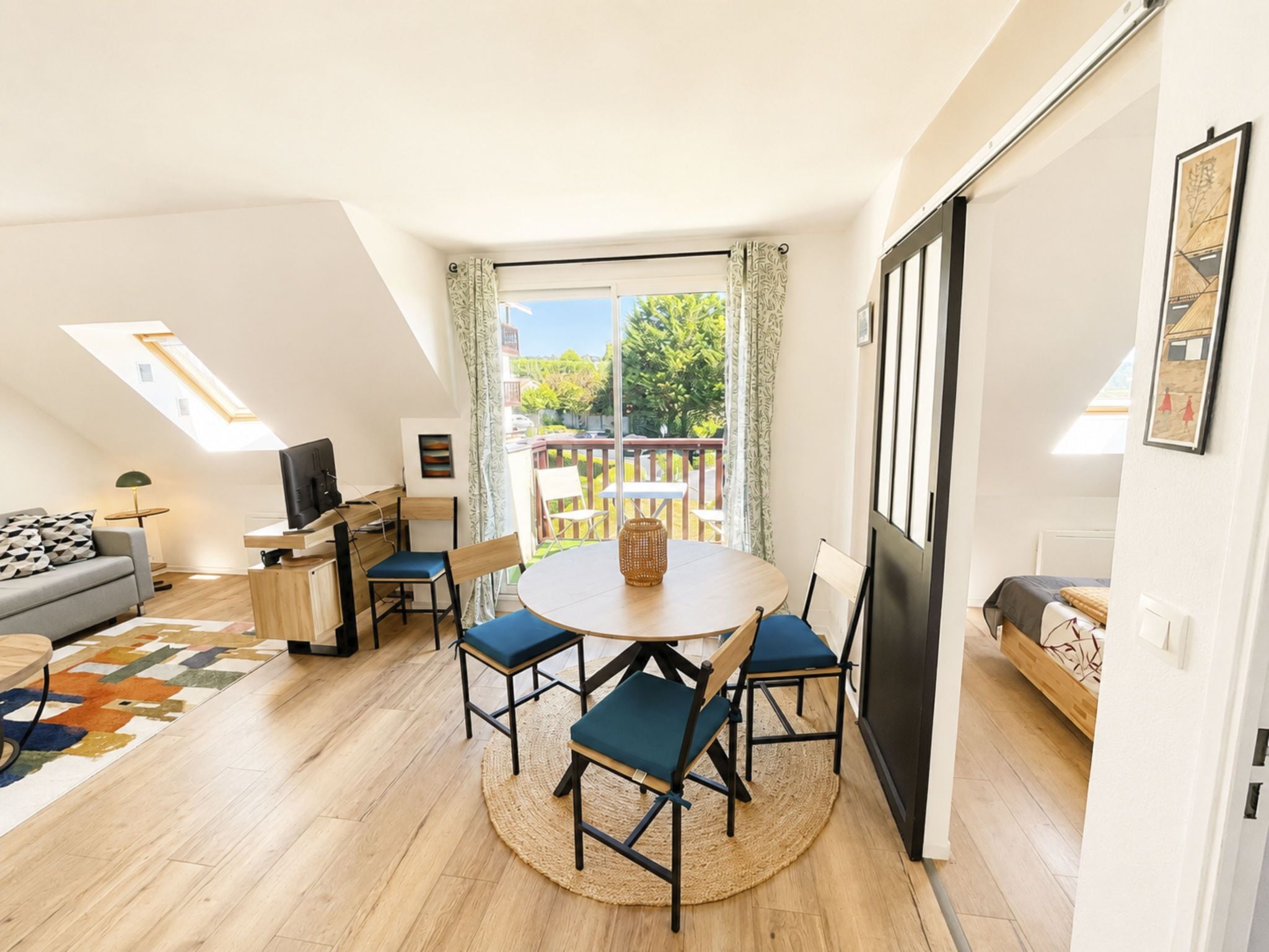 Ein modernes Wohnzimmer mit einem runden Tisch, Stühlen, einer Couch und einem Fernseher.
