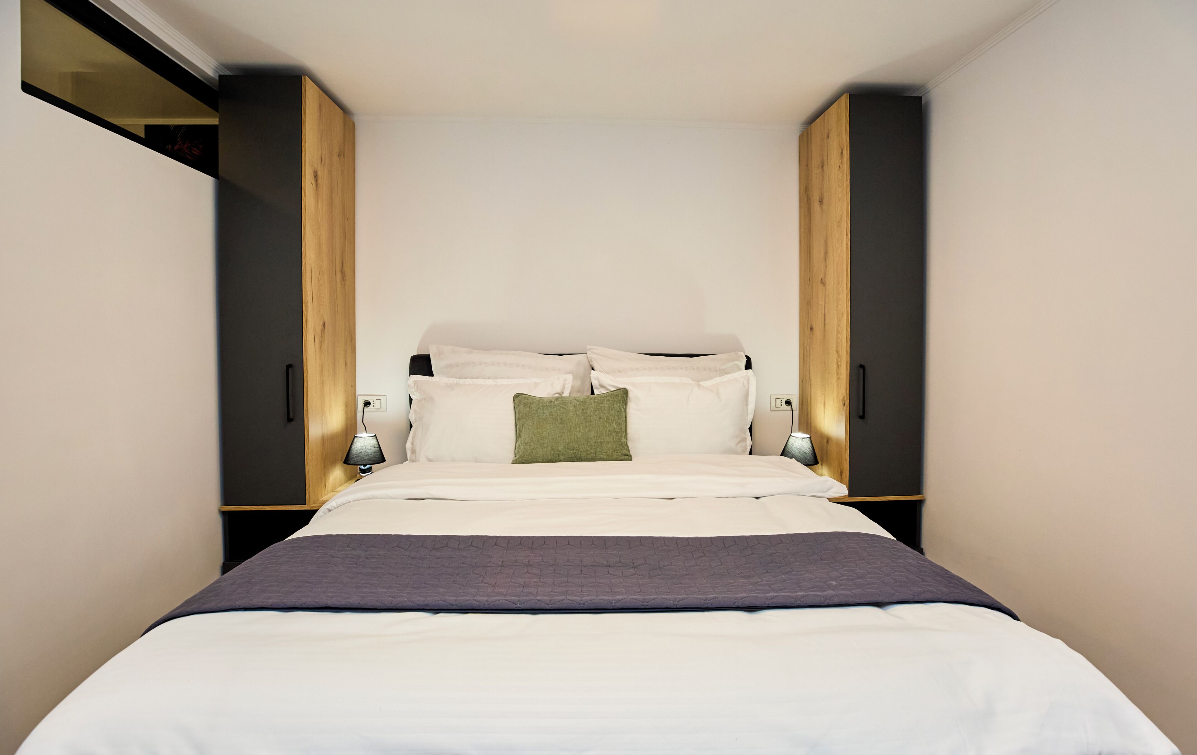 Une chambre à coucher avec un lit, des lampes de chevet et une armoire.