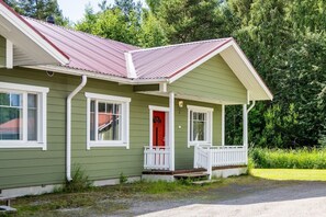 A green house with a red door, white trim, and a porch. - Apartment A 3 Talja, Private Sauna By Lapland Host (Rovaniemi)
