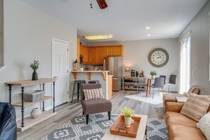 A modern living room with a sofa, coffee table, and a dining area with chairs. - Sierra Foothills Retreat with public Lake Access (Copperopolis)