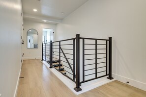 Eine Treppe mit Metallgeländer, Holzhinweisen und einer weißen Wand.