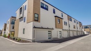 A modern multi-story residential building with a clean facade, large windows, and a flat roof. - Brand-New Townhome Near Dtwn Salt Lake & Trails! (Millcreek)