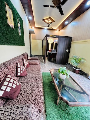 A modern living room with a sofa, a glass coffee table, and a reception desk.