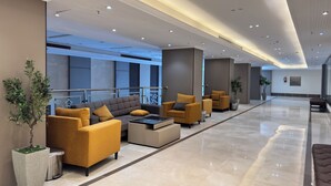 En moderne lobby med sofaer, et sofabord og en skraldespand.