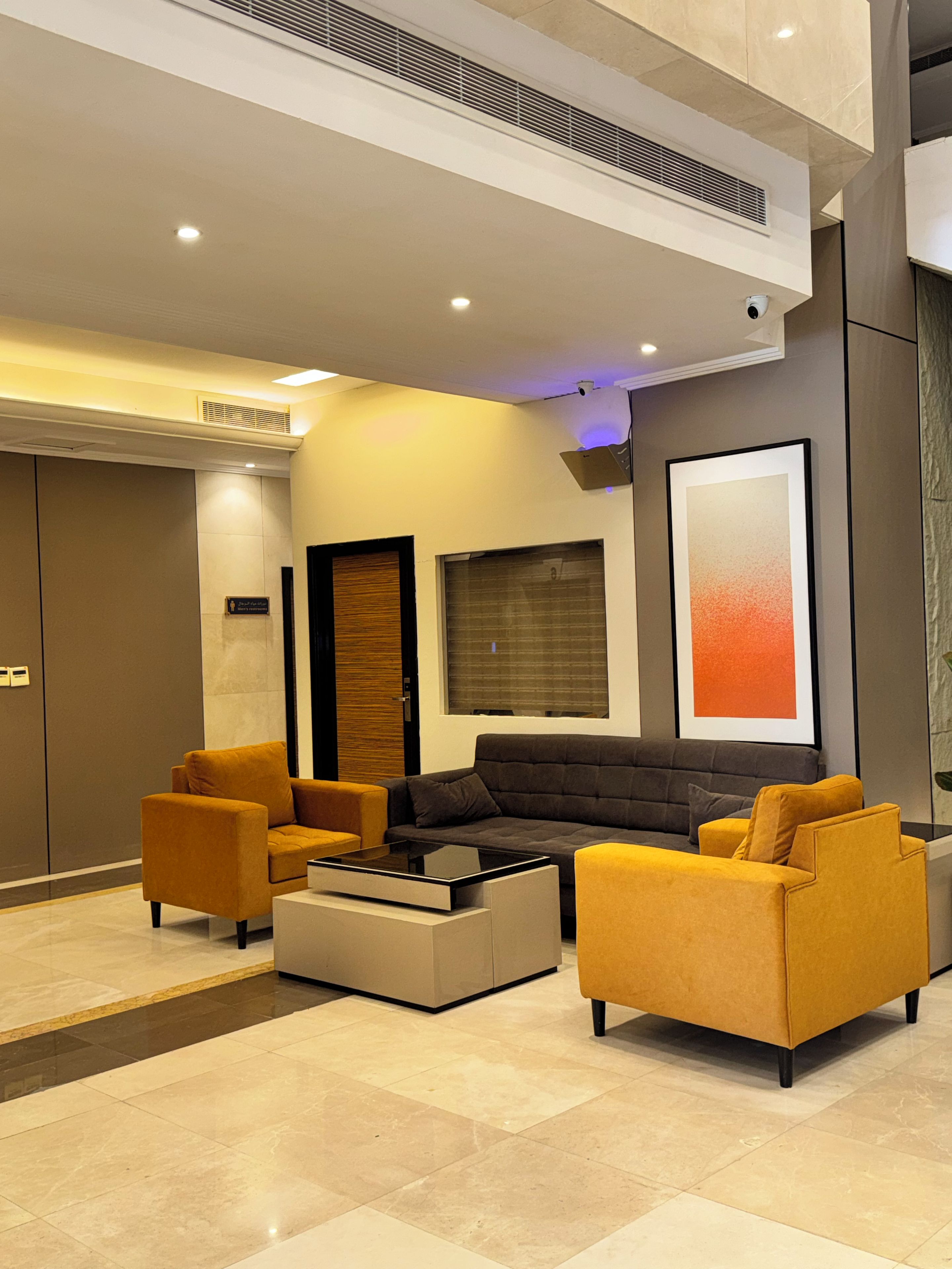 A modern living room with a sectional sofa, two armchairs, and a coffee table.