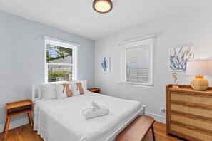 A bedroom with a bed, bedside tables, a dresser, and artwork on the walls. - Private Pool + Firepit + Beach Gear | Short Drive to Beach + Las Olas | Al Mare (Fort Lauderdale)