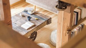 Une table en bois rustique, ornée de livres, d’une tasse et d’un petit objet décoratif.