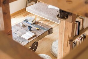 Ein rustikaler Holztisch mit Büchern, einer Tasse und einem kleinen Dekorationsgegenstand.