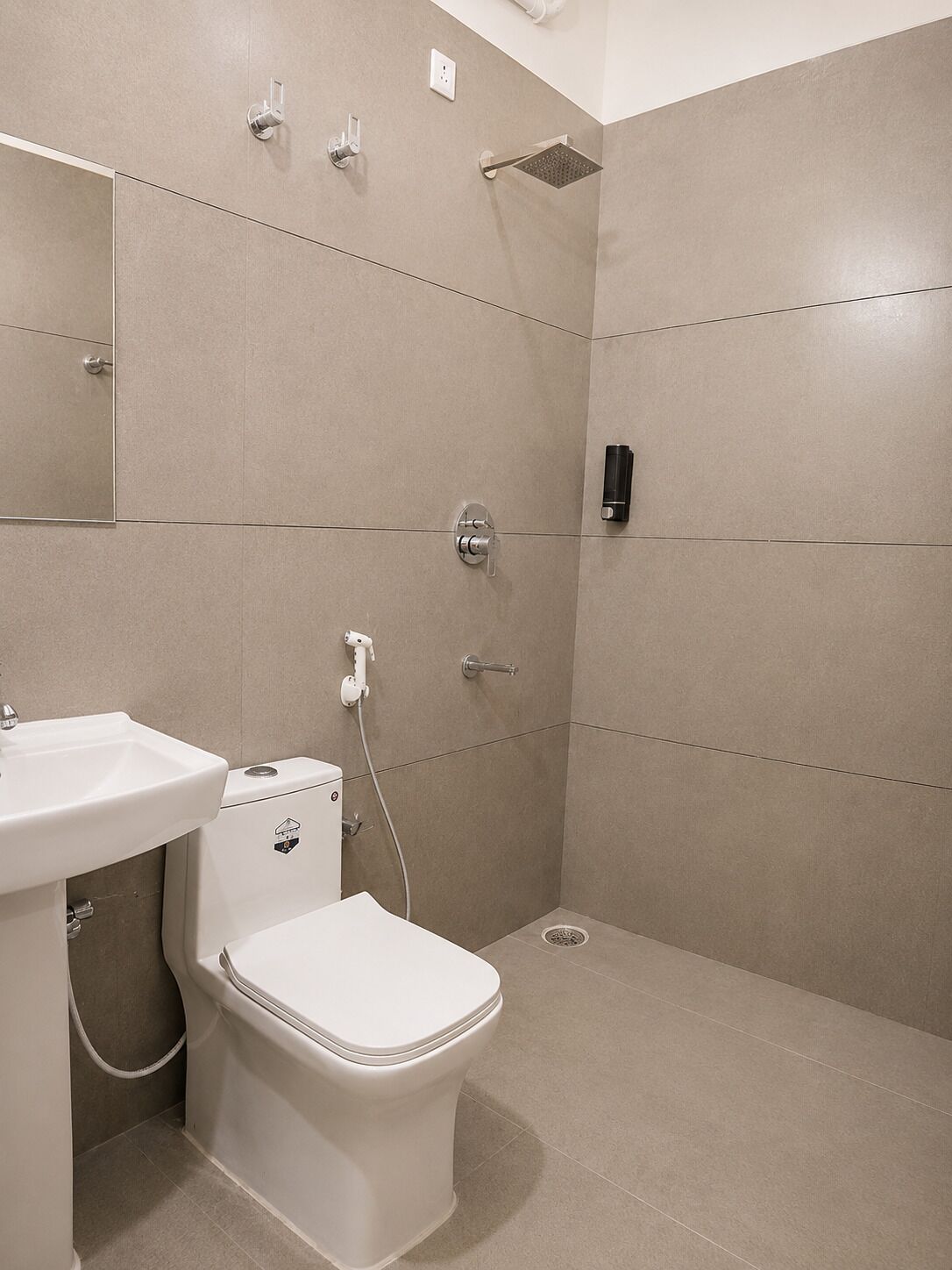 Un baño moderno con inodoro, lavamanos y ducha.