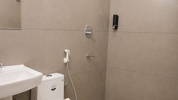 Un baño moderno con inodoro, lavamanos y ducha.
