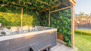 A hot tub under a wooden pergola with a lush green wall backdrop. - Westerlön Hüs 1999 - "Westerlön Hüs 1999" Vacation Home (Sylt)