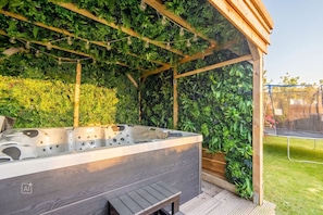 A hot tub under a wooden pergola with a lush green wall backdrop. - Westerlön Hüs 1999 - "Westerlön Hüs 1999" Vacation Home (Sylt)