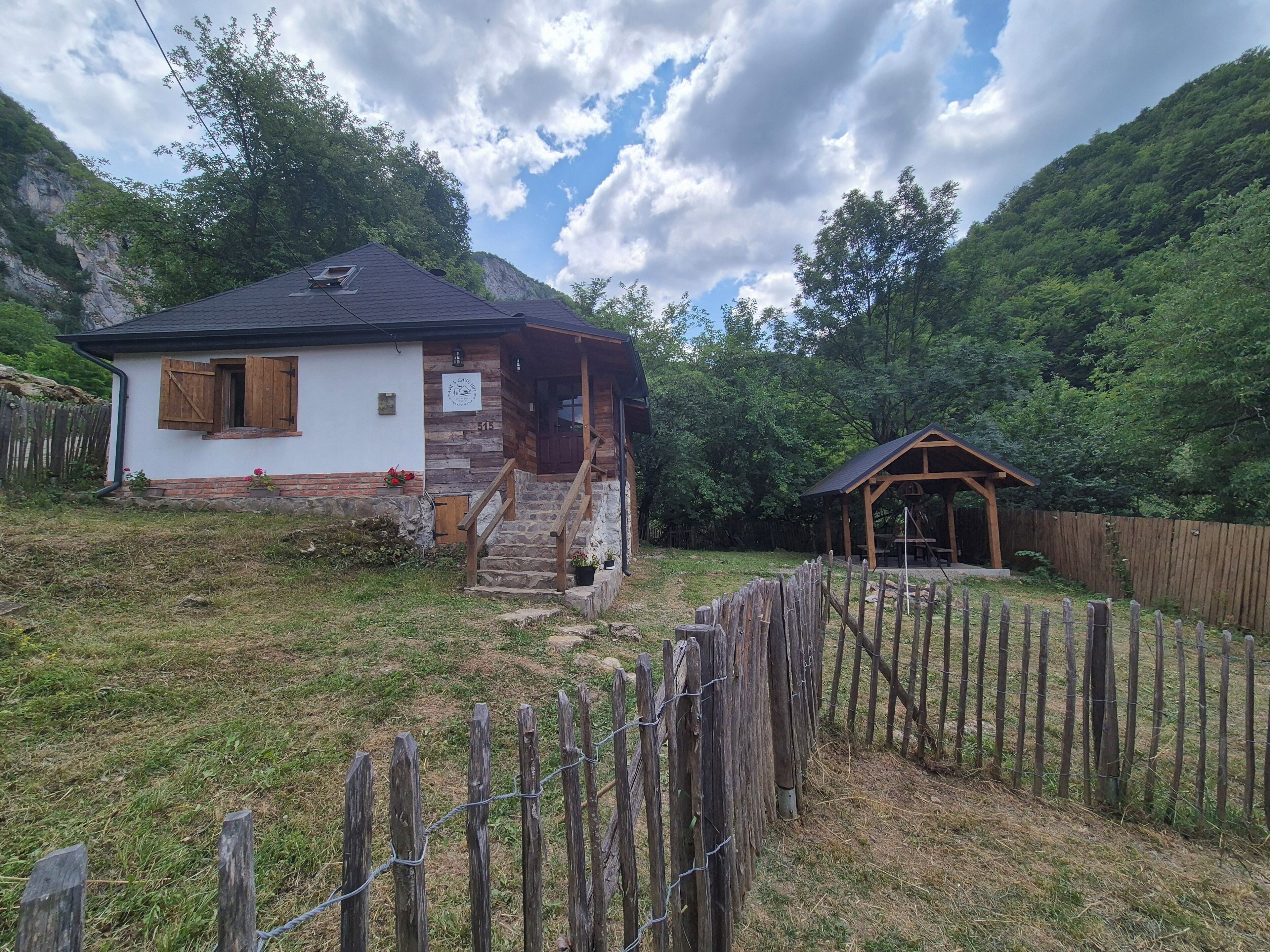 Une cabane rustique avec des fondations en pierre, un revêtement extérieur en bois et un petit porche.