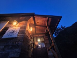 Ein Holzhaus mit einem Schild, auf dem 'Bat's Cave Hut' und die Nummer '515' stehen.