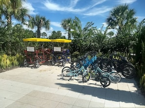A paved area with bicycles and a red and blue cart with 'RENT ME AT THE AQUAPARK' signs. - Disney Dreams Luxury Home with Private Water Park (Kissimmee)