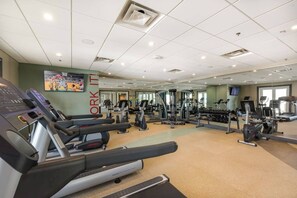 A gym with treadmills, elliptical machines, and weight equipment. - Disney Dreams Luxury Home with Private Water Park (Kissimmee)