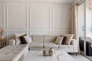 A modern living room with a sofa, a coffee table, and decorative vases. - Modern 2BR Apartment Near Agora Mall (Santo Domingo)