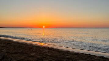 Una spiaggia al tramonto con cielo sereno e mare calmo.