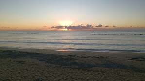A beach with a sunset, calm sea, and a rocky shoreline. - Vacation Home 300 m from the Sea, Ideal for Those Seeking Relaxation, Privacy, and Comfort (Avola)