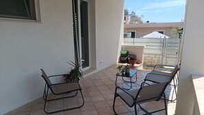 A balcony with two chairs, a small table, and potted plants. - Vacation Home 300 m from the Sea, Ideal for Those Seeking Relaxation, Privacy, and Comfort (Avola)