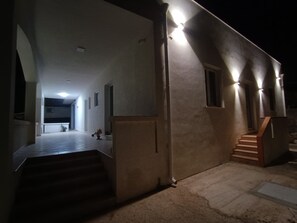 A modern building with a staircase leading to an upper level, a hallway with a plant, and a well-lit exterior. - Vacation Home 300 m from the Sea, Ideal for Those Seeking Relaxation, Privacy, and Comfort (Avola)