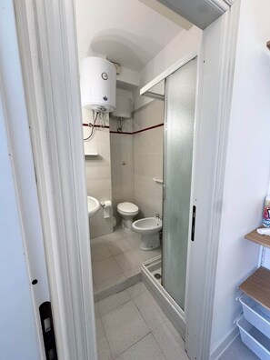 Ein Badezimmer mit Toilette, Bidet und Duschkabine.
