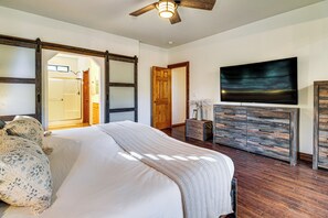 A bedroom with a bed, wooden dresser, and a television on the wall. - Forests, Fairways & Lake Fun! Show Low Getaway (Show Low)