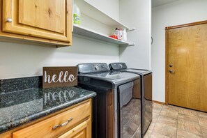 A laundry room with a Samsung washer and dryer, wooden cabinets, a 'hello' sign, and a door. - Forests, Fairways & Lake Fun! Show Low Getaway (Show Low)