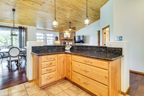 A kitchen with wooden cabinets, granite countertops, and pendant lighting. - Torreon Family Retreat, 4BR Mountain Home (Show Low)