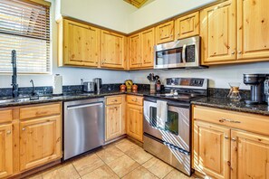 A kitchen with wooden cabinets, stainless steel appliances, and a granite countertop. - Torreon Family Retreat, 4BR Mountain Home (Show Low)