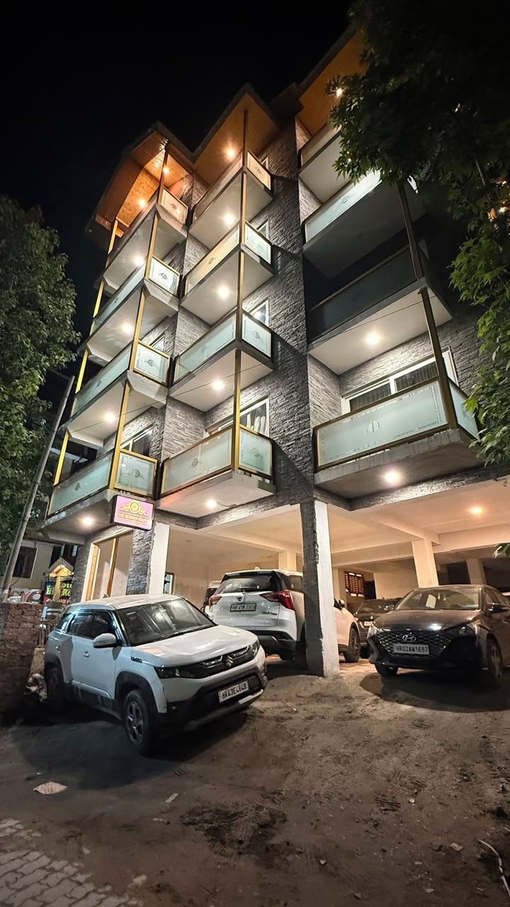 Un edificio de varios pisos con un estacionamiento al frente.
