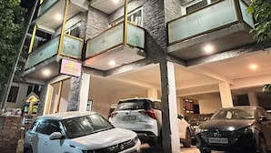 Un edificio de varios pisos con un estacionamiento al frente.