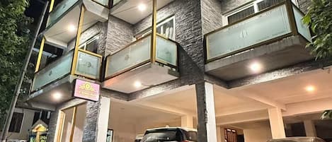Un edificio de varios pisos con un estacionamiento al frente.