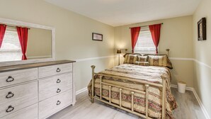 Een slaapkamer met een bed, een kaptafel en een spiegel.