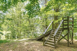 Eine Holztreppe führt zu einer Plattform in einem bewaldeten Gebiet.