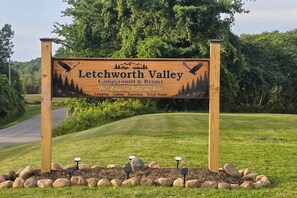 Letrero de madera para el Letchworth Valley Campground & Resort, con un gráfico de una montaña y un águila.