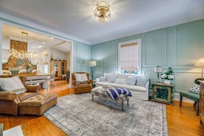 Ein Wohnzimmer mit Kamin, einer Couch, einem Couchtisch und einem Essbereich.
